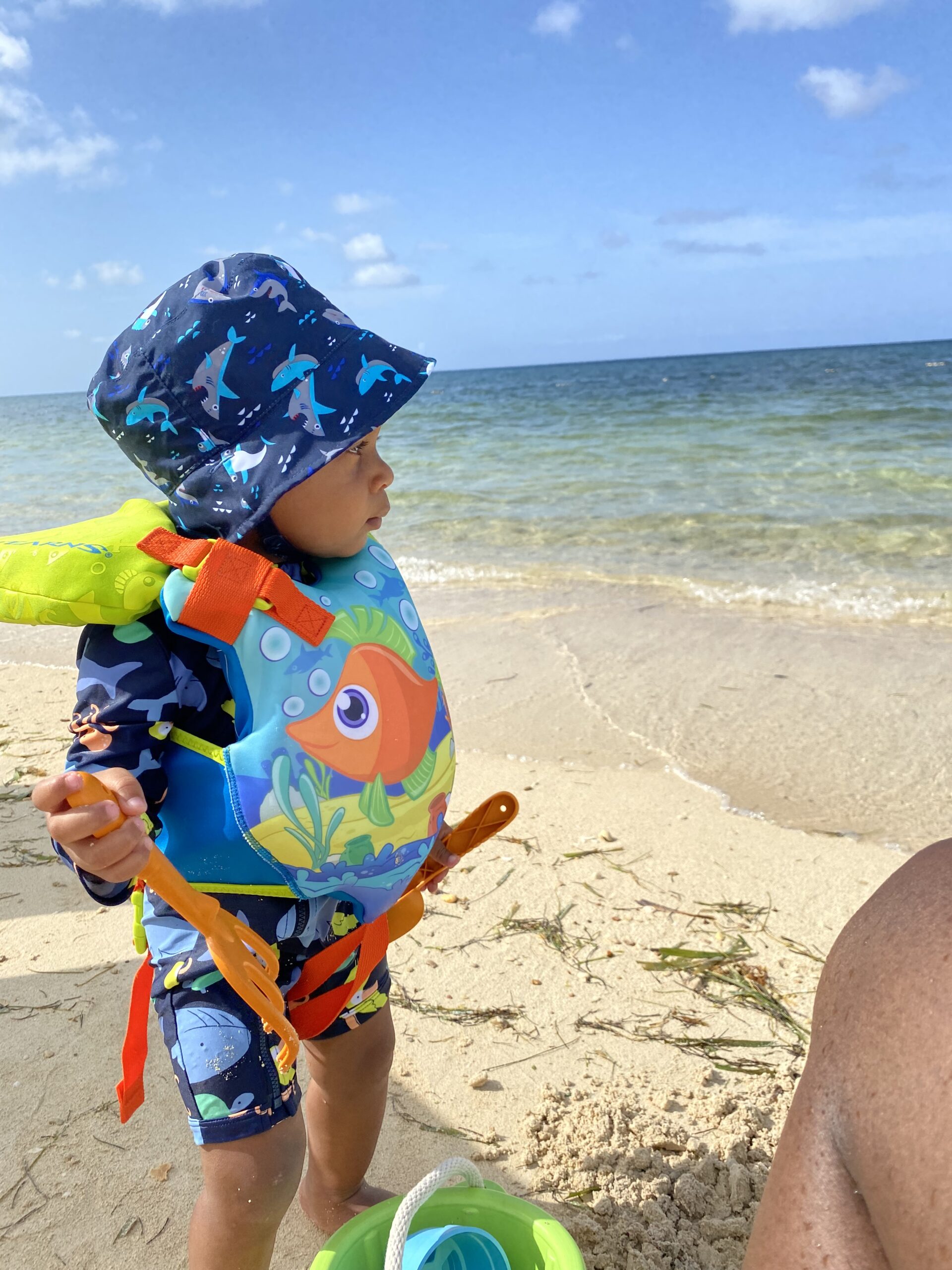 Young boy standing at the shoreline gazing at the Caribbean Sea in Jamaica