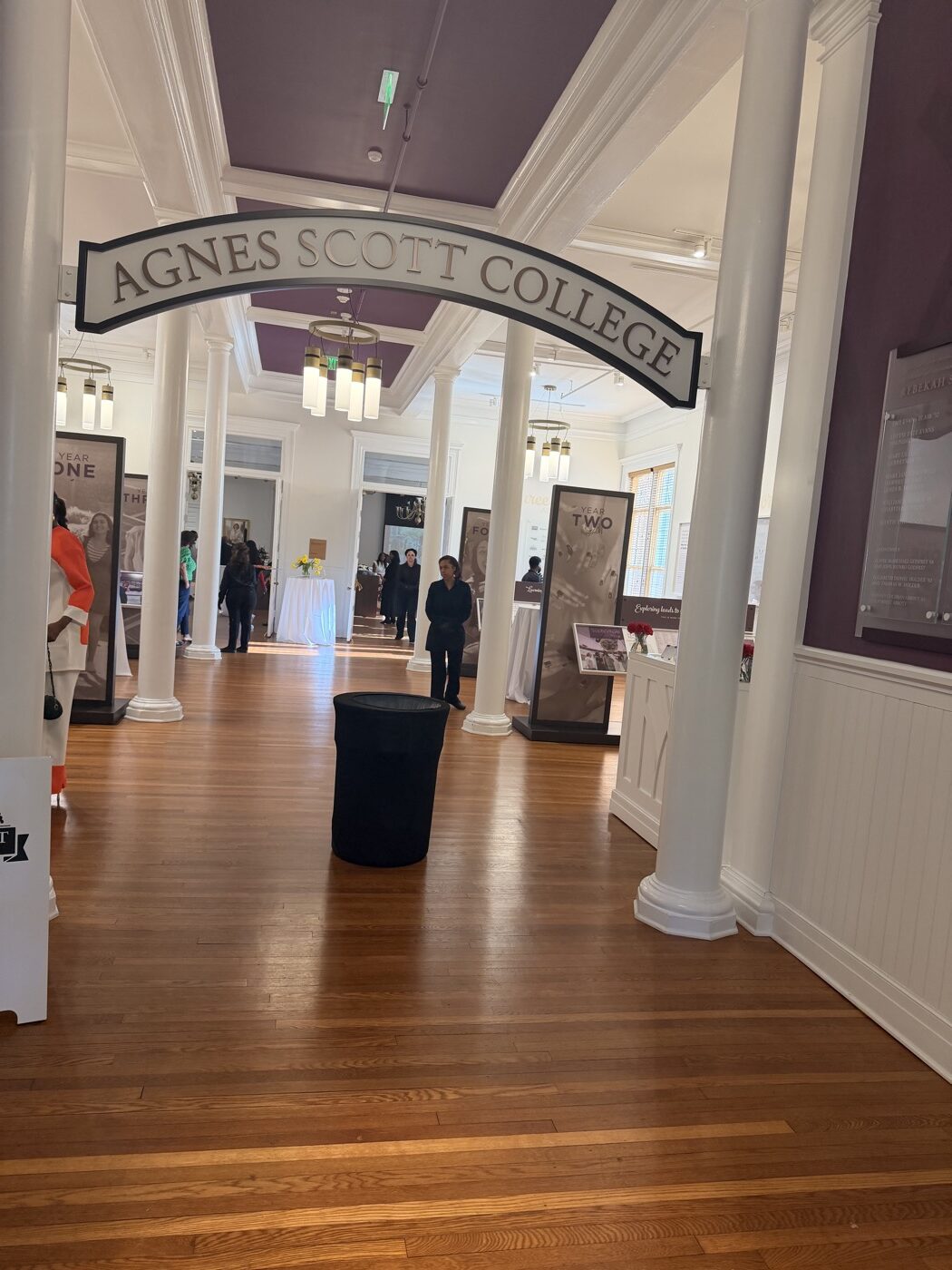 Interior of Agnes Scott College with white classical columns, warm hardwood floors, and the signature purple ceiling