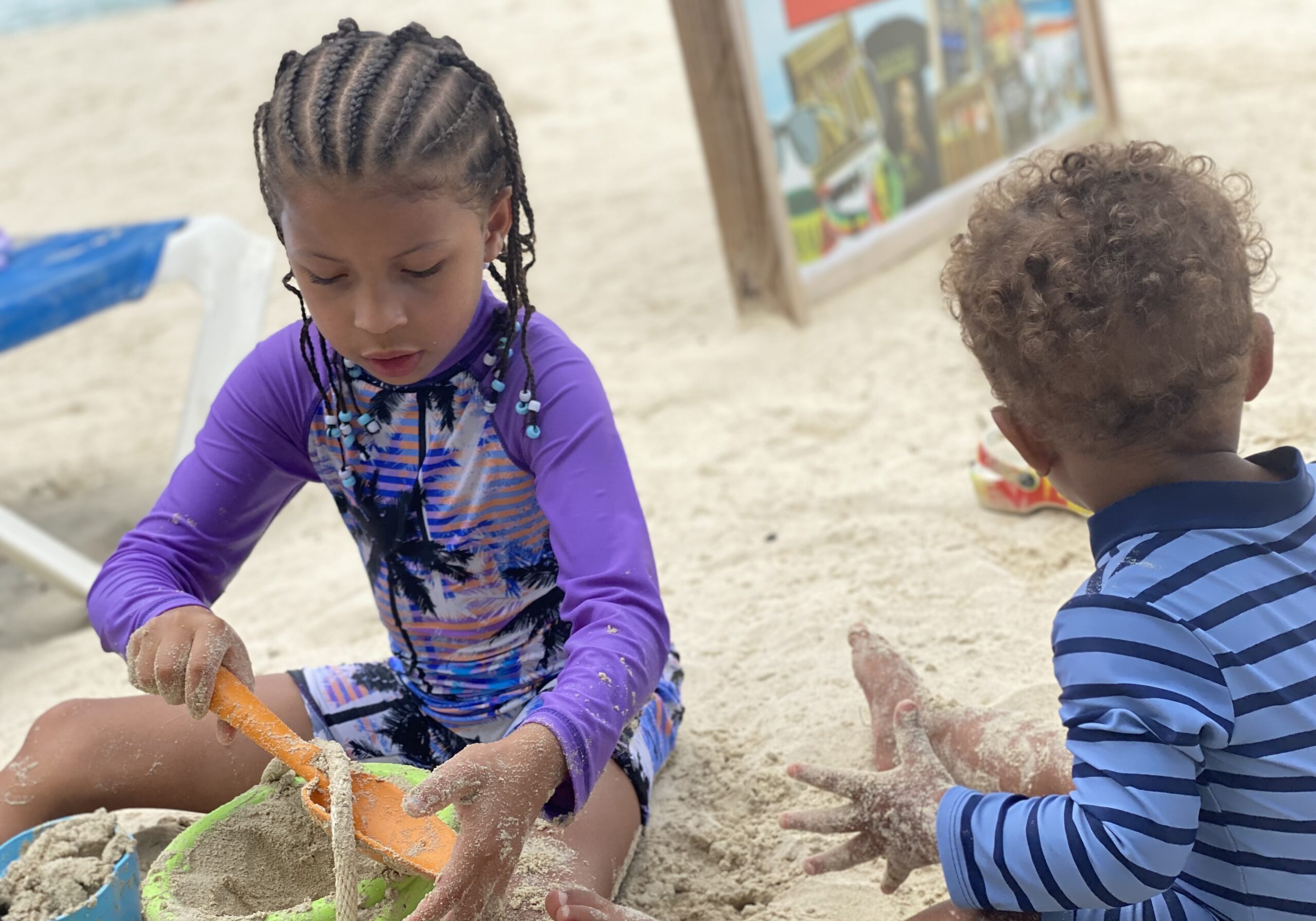 Two kids playing with sand toys on a Jamaican beach
